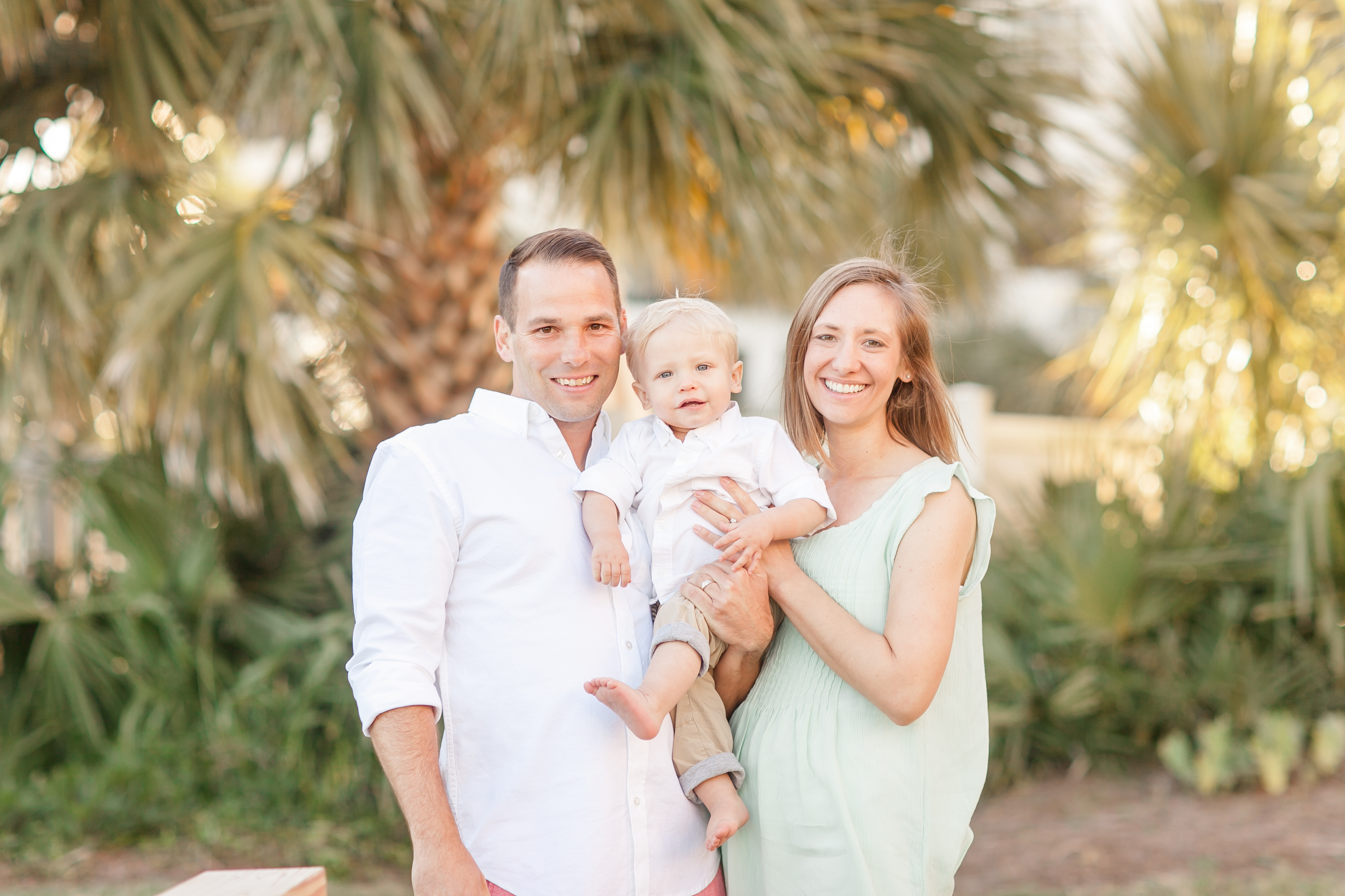 family poses in front of palm trees at wild dunes beach resort