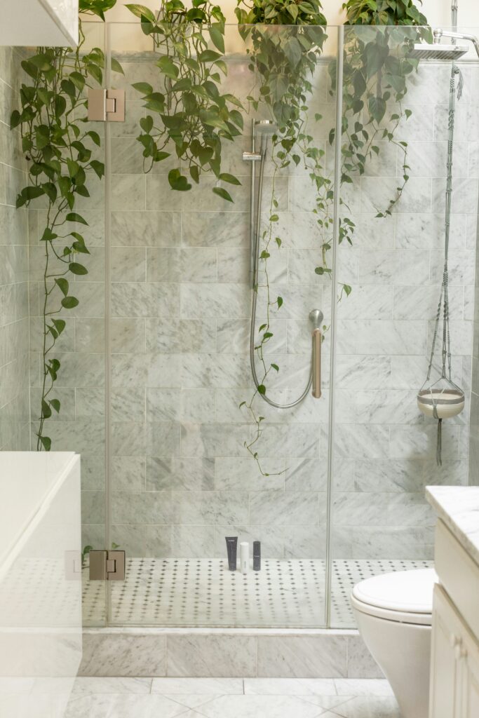 a white marble shower with greenery