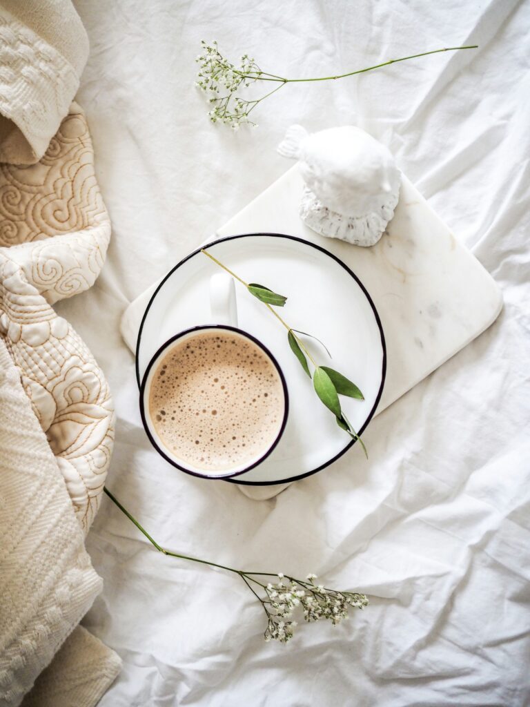 coffee sitting on a white tray on a bed