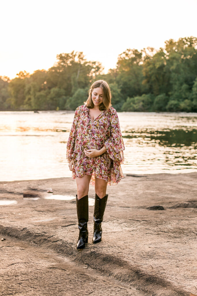 Expecting mother in floral dress posing by the water during Columbia SC maternity photo session.